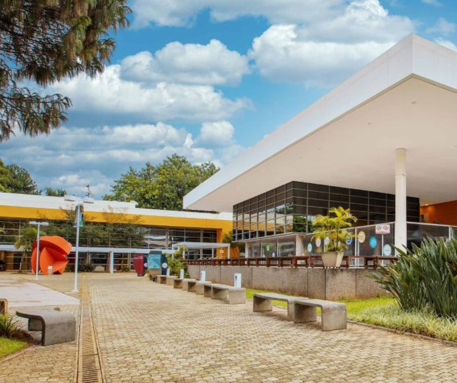 Edifício contemporâneo do SENAC com telhado branco e esculturas no pátio